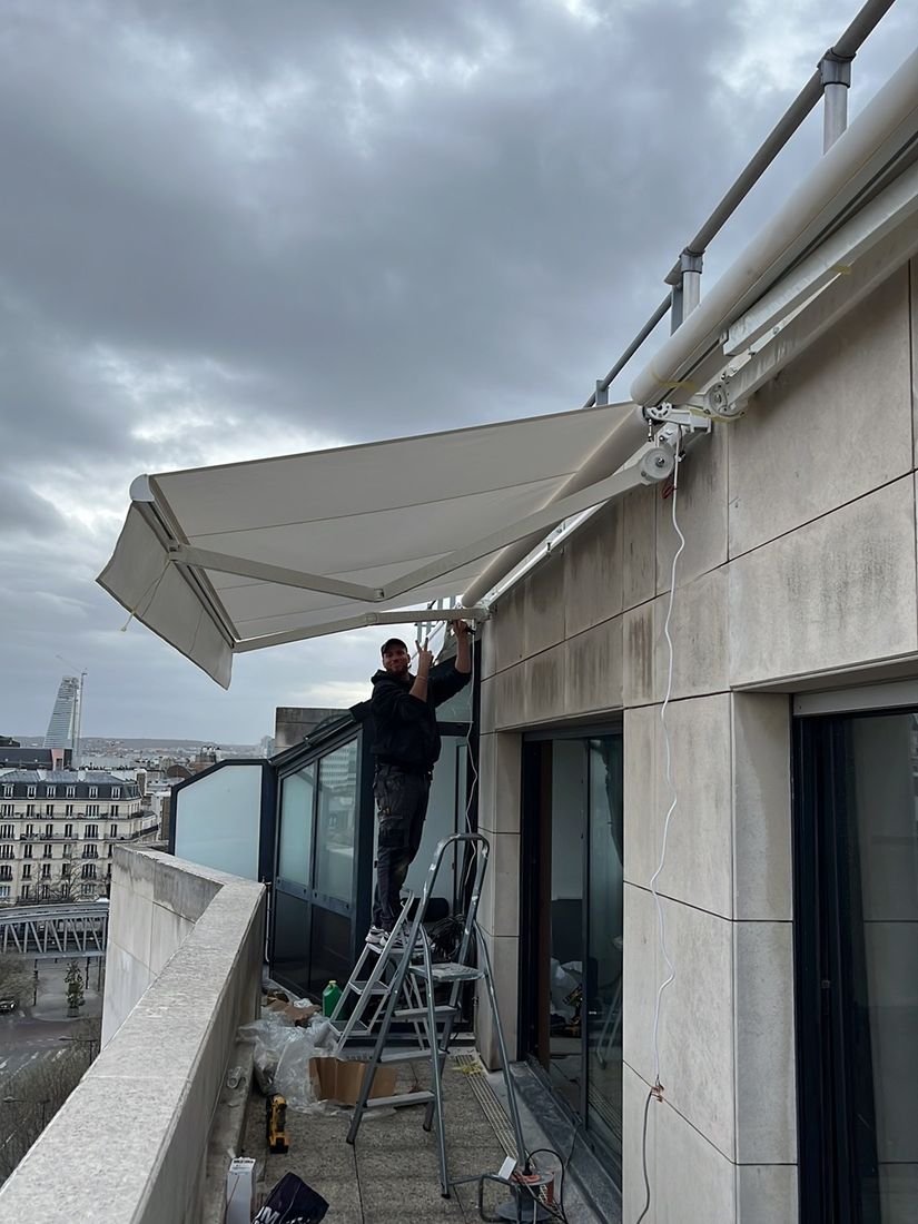 Technicien Store Xpress reglant les bras d un store banne pendant l installation