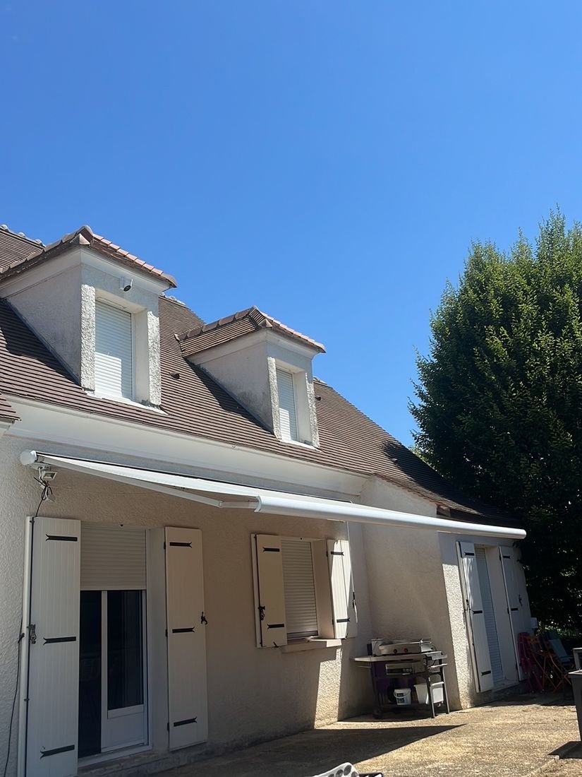 Store banne coffre déployé au-dessus d'une terrasse de maison