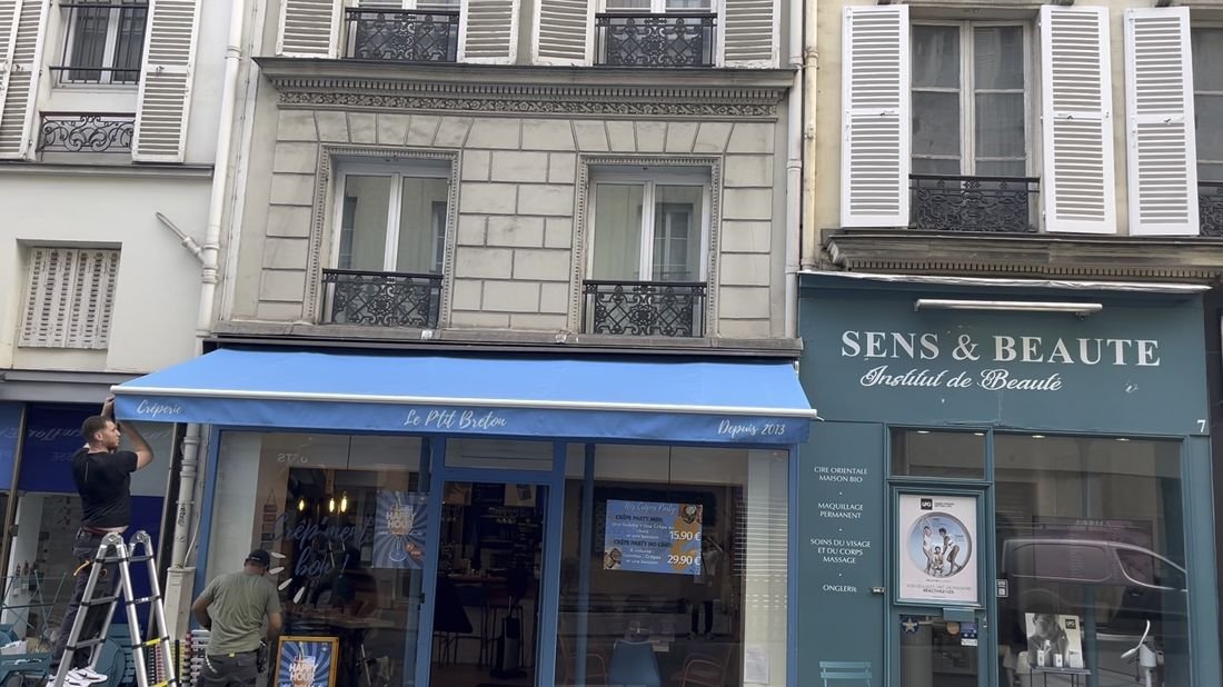Store banne bleu installé sur la devanture d'une boutique à Paris