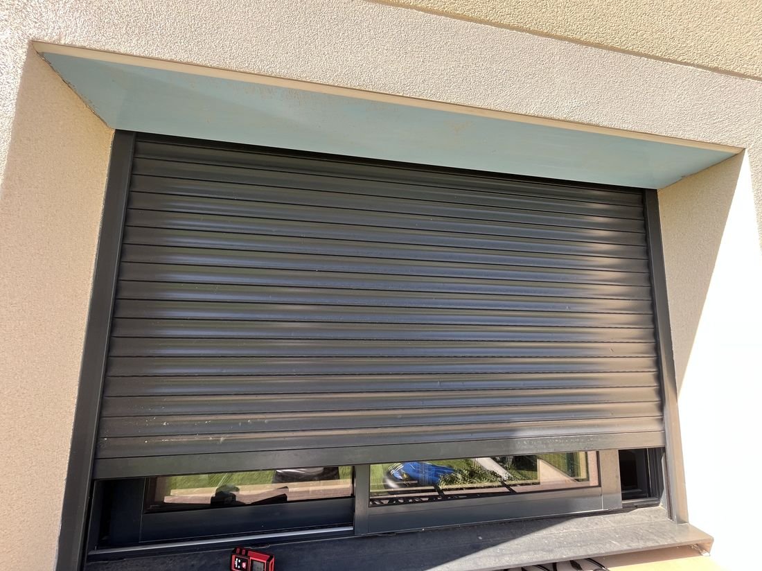 Volet roulant gris anthracite posé sur une baie de maison moderne